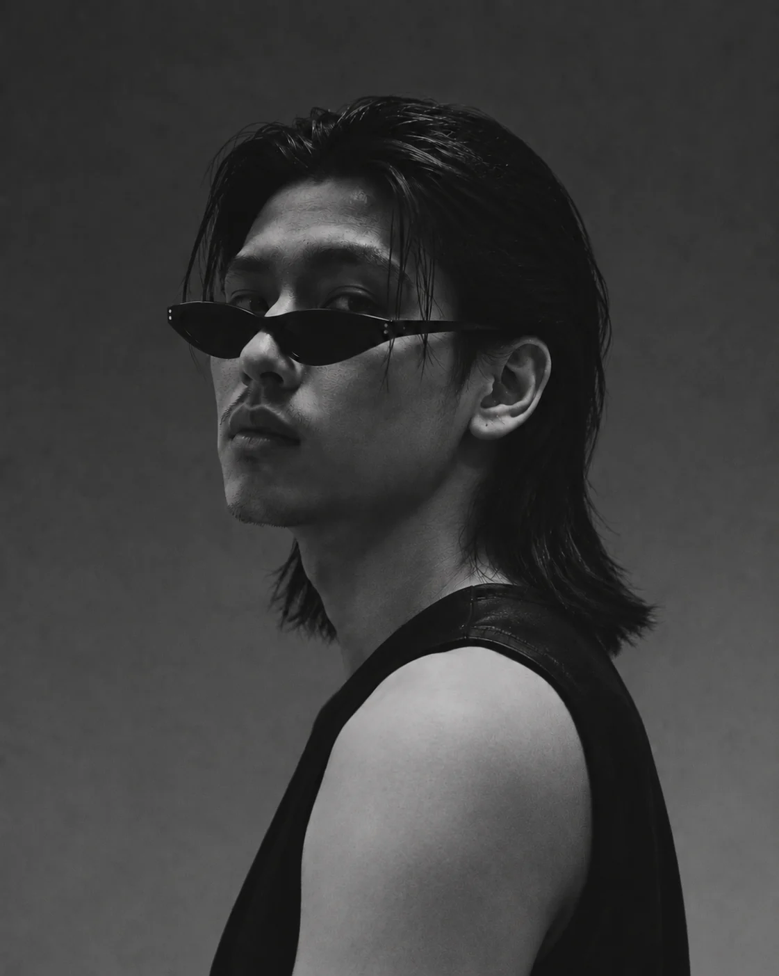 Black-and-white BrozKey editorial portrait with a layered hairstyle and narrow sunglasses