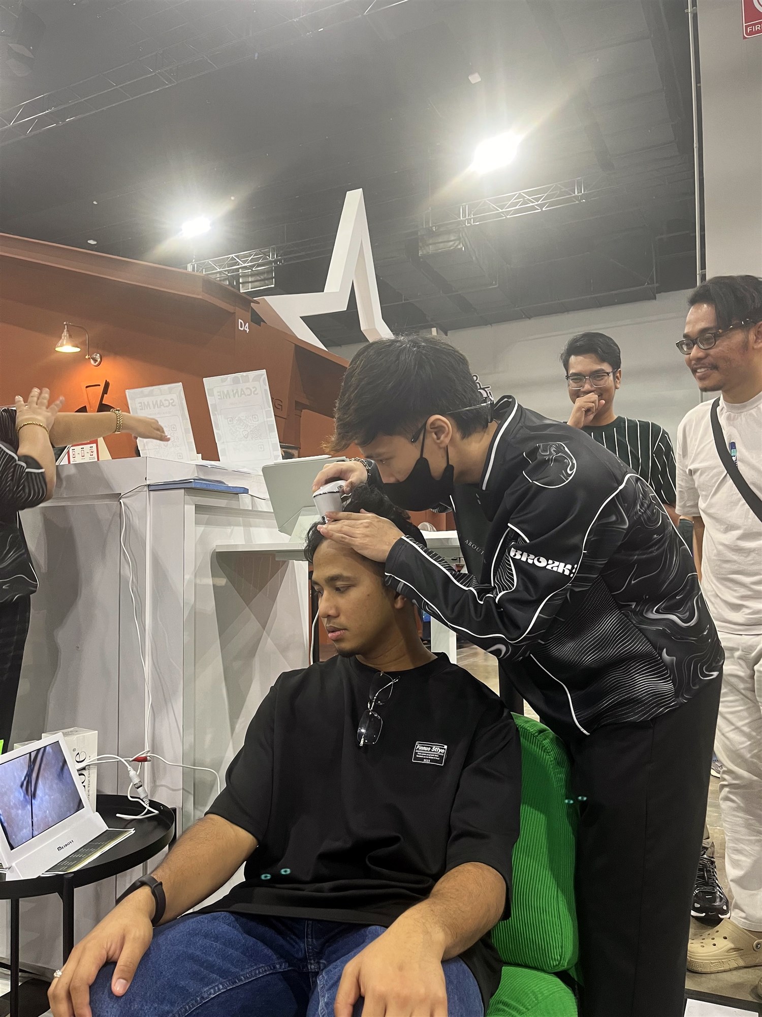 A BrozKey barber giving a haircut at the pop-up booth
