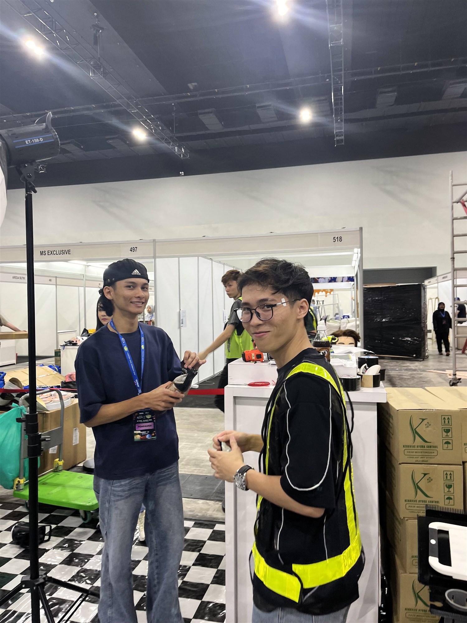 Team members preparing equipment at the MITEC booth