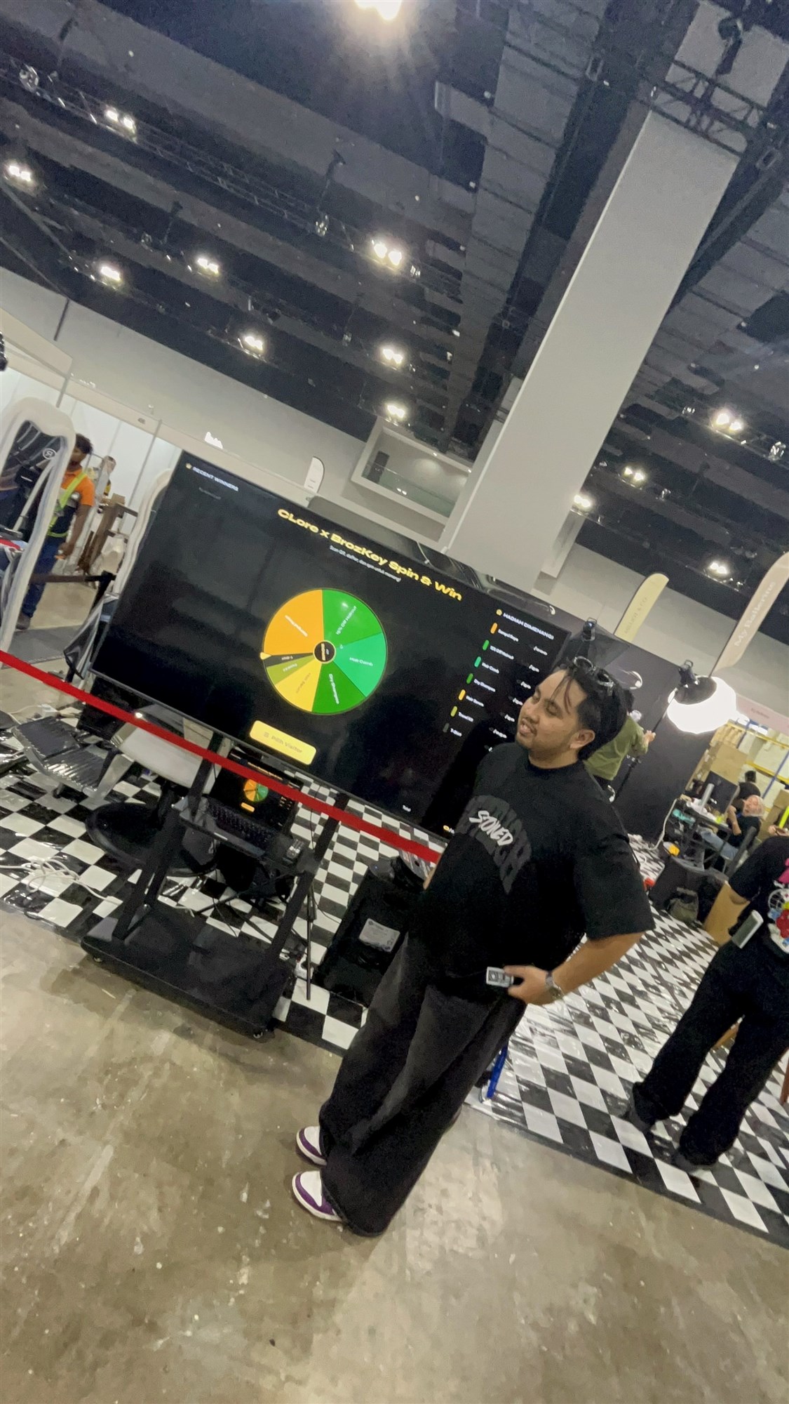 A visitor beside the spin-and-win screen at the booth